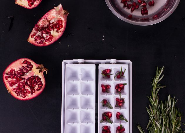 Samppanja-rosmariini-granaattiomenacocktail: Järjestä rosmariinilehdet ja granaattiomenansiemenet jääkuutioalustoille