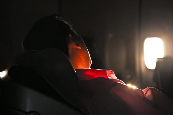mies nukkuu istuimella lentokoneen Sunrise